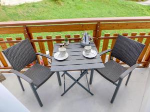 un tavolo e 2 sedie su un balcone con tavolo di Apartment Barzettes-Vacances 454 - Entrée N- 14 by Interhome a Vermala