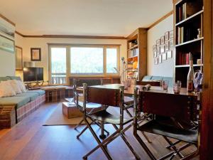 a living room with a table and a couch at Apartment Chesa Sonnalpine B 46 by Interhome in St. Moritz +17 photos