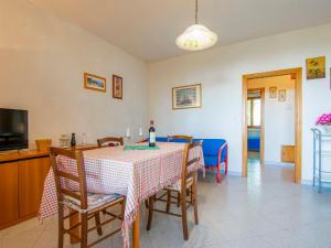 a dining room with a table with chairs and a television at Apartment Montaleo 5 by Interhome in Casale Marittimo