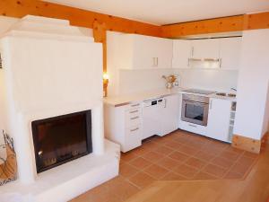 a kitchen with white cabinets and a fireplace at Apartment Le Bristol C54 by Interhome in Villars-sur-Ollon