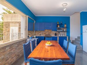 cocina azul con mesa de madera y sillas azules en Apartment Tonino by Interhome, en Stintino