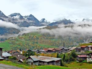 a village in the mountains with fog in the valley at Holiday Home Peisel by Interhome in Disentis