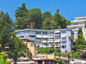 an apartment building on a hill with trees at Apartment Suite Classic-16 by Interhome in Ascona