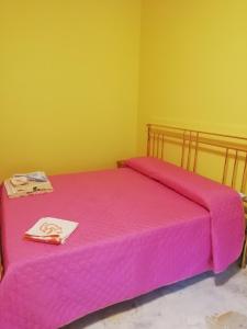 - un lit avec un couvre-lit rose dans l'établissement Casa Ai Cappuccini, à Randazzo