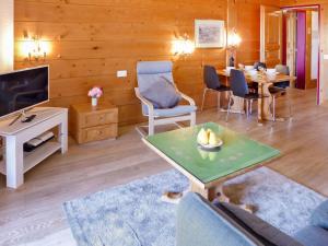 a living room with a table and a tv at Apartment Le Bristol A54 by Interhome in Villars-sur-Ollon