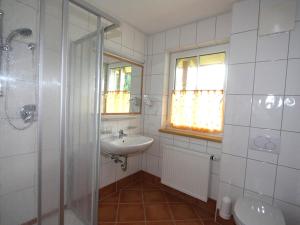 ein weißes Bad mit einem Waschbecken und einer Dusche in der Unterkunft Apartment Hofresidenz-3 by Interhome in Altenmarkt im Pongau