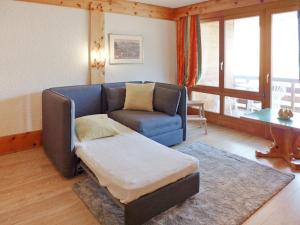 a living room with a blue couch and a table at Apartment Le Bristol A54 by Interhome in Villars-sur-Ollon +23 photos
