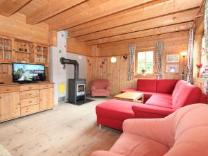 シュトゥンムにあるHoliday Home Alpendorf-1 by Interhomeのリビングルーム(赤いソファ、テレビ付)