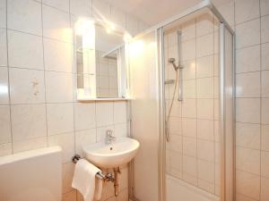 een witte badkamer met een wastafel en een douche bij Apartment Am Birkenhain-17 by Interhome in Seefeld in Tirol