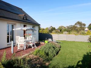 a yard with a table and chairs and an umbrella at Holiday Home l'Hermine by Interhome in Ploubazlanec