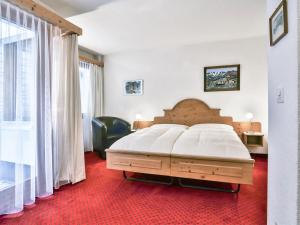 グリンデルワルトにあるApartment Chalet Abendrot-2 by Interhomeの赤いカーペットフロアのベッドルーム1室(大型ベッド1台付)