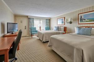 a hotel room with two beds and a flat screen tv at Ogunquit The Milestone Inn in Ogunquit +34 photos