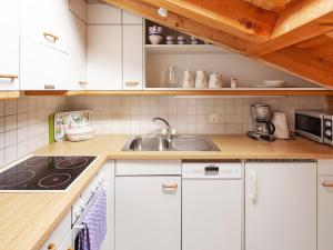 a kitchen with white cabinets and a sink at Apartment Chalet Abendrot-23 by Interhome in Grindelwald