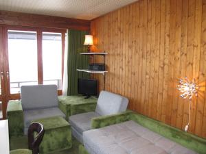 a living room with two chairs and a couch and a tv at Studio Résidence Velan-2 by Interhome in Les Collons