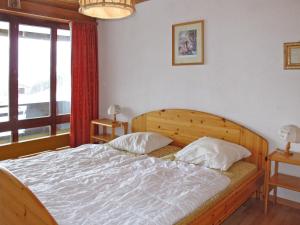1 dormitorio con cama y ventana grande en Apartment Résidence Essert-25 by Interhome, en Les Collons