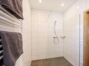ein Bad mit einer Dusche und weißen Fliesen in der Unterkunft Apartment Rubin - SLD600 by Interhome in Schladming