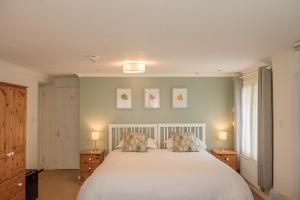 a bedroom with a white bed with two pillows at Mynd House in Church Stretton