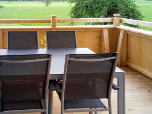 a table and chairs on a deck with a fence at Apartment Zillertalblick - FGZ230 by Interhome in Strass im Zillertal