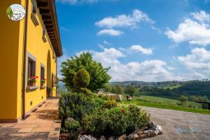 un edificio giallo con un sentiero che conduce a un giardino di Antiche Vie B&B a Serramazzoni