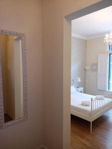 1 dormitorio con cama blanca y espejo en Lumine Luxury Suites by gaiarooms, en Barcelona