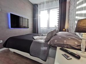 1 dormitorio con cama y mesa con mando a distancia en Ostoja Piękności, en Krynica-Zdrój