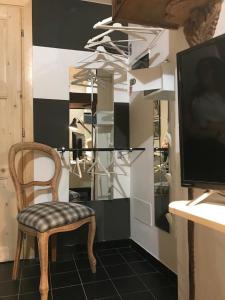 a chair sitting in a room with a television at Sanctus Syrus 2 in Albenga