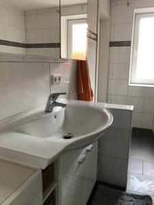 a white sink in a bathroom with a window at Ferienwohnung Black Beauty in Wernigerode +11 photos