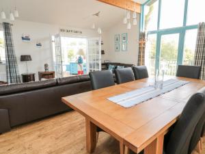 een eetkamer met een houten tafel en een bank bij Sea View Lodge in Morpeth