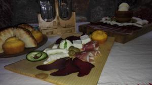 a cutting board with meat and vegetables on a table at Houses Amanet in Kolašin