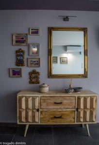 
a wooden table with a mirror and a picture on it at Magical view studios Asproneri, Kamena Vourla in Kamena Vourla
