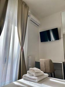 バーリにあるRelais Petruzzelliのベッド1台、窓、タオル付
