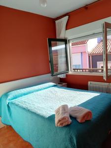 una camera da letto con un letto e due asciugamani di O Encontro a Fisterra (Finisterre)