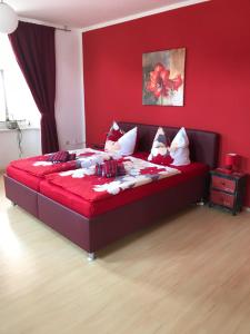 ein rotes Schlafzimmer mit einem Bett mit einer roten Wand in der Unterkunft Gasthof " Zur Brücke" in Alsleben