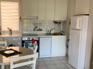 een keuken met een tafel en een witte koelkast bij APARTAMENTO HENDAYA Playa-wifi-parking in Hendaye +10 foto's