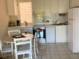 een keuken met een tafel en witte apparaten bij APARTAMENTO HENDAYA Playa-wifi-parking in Hendaye