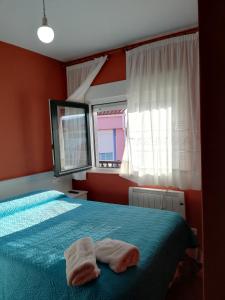 a bedroom with a bed with two towels on it at O Encontro in Fisterra