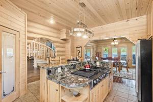 a kitchen with a stove top oven in a cabin at Antler Cove Log Home in Sagle