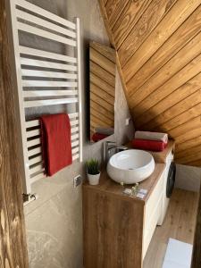 La salle de bains est pourvue d'un lavabo blanc sur un comptoir en bois. dans l'établissement Apartamenty Butorowy, à Kościelisko