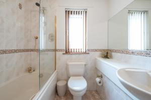 a bathroom with a toilet and a tub and a sink at Bowmore in Lossiemouth +32 photos
