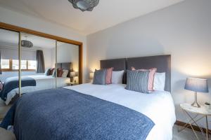 a bedroom with a large bed with a blue blanket at Bowmore in Lossiemouth