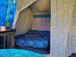a bed in a tent in a room at 4 persoons ingerichte tent op kleine camping in Anna Paulowna