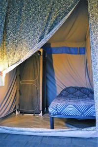Кровать или кровати в номере 4 persoons ingerichte tent op kleine camping
