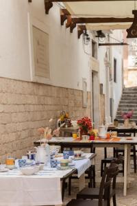 un grupo de mesas y sillas con comida. en Camere Caroseno, en Castellana Grotte