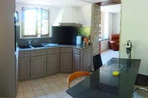uma cozinha com um balcão e uma mesa com cadeiras em * Appartement rez de chaussée Frontière Suisse * em Delle