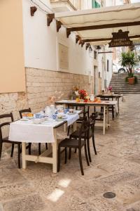 una fila de mesas y sillas en un patio en Camere Caroseno, en Castellana Grotte