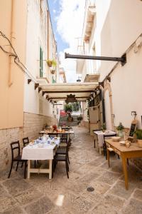 an outdoor patio with tables and chairs and buildings at Camere Caroseno in Castellana Grotte