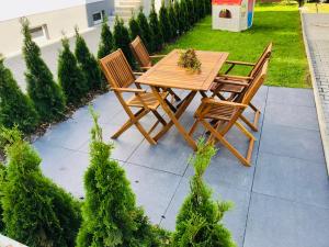 a wooden table and chairs on a patio at Central-Modern, The Sunshine by SA-Grandeur in Friedrichshafen