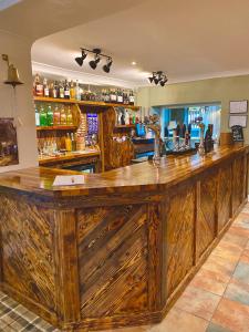 a bar with a large wooden counter in a room at The Gun at Ridsdale in Ridsdale