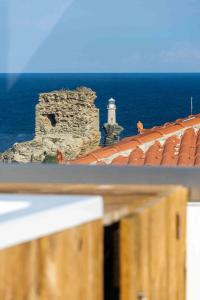 widok na latarnię morską i budynek z latarnią morską w obiekcie Castel Abaso Boutique Apartments w mieście Andros