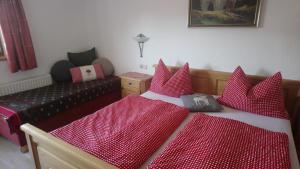 a bedroom with two beds with red pillows at Riedlhof in Kössen